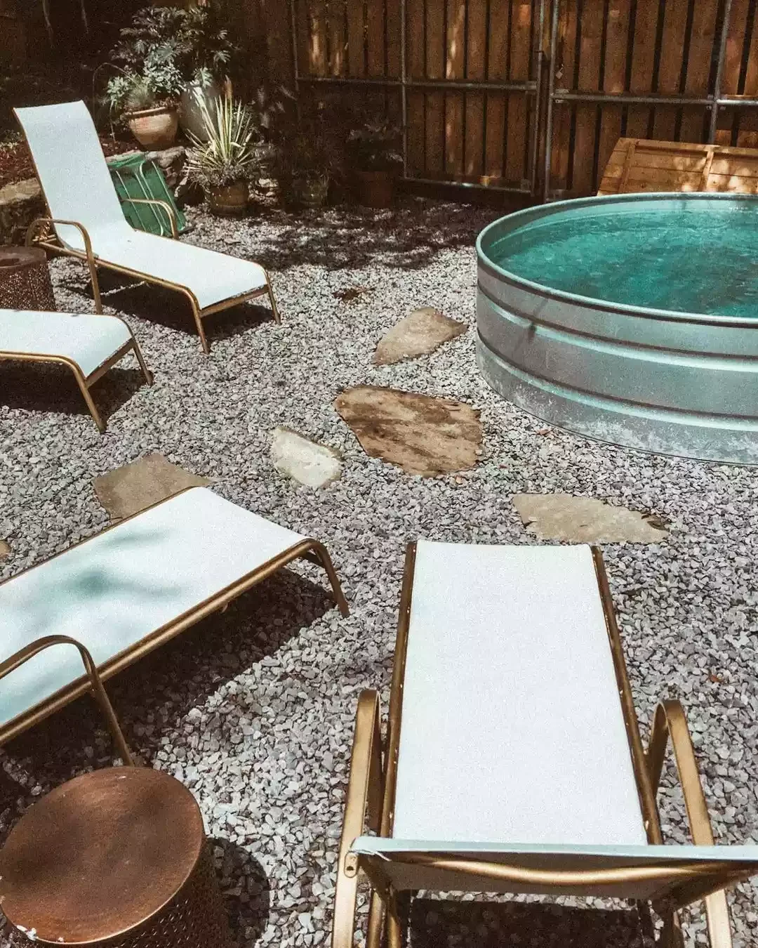 20 Creative and Budget-Friendly Gravel Patio Design Ideas 14 Add a Small Stock Tank Pool