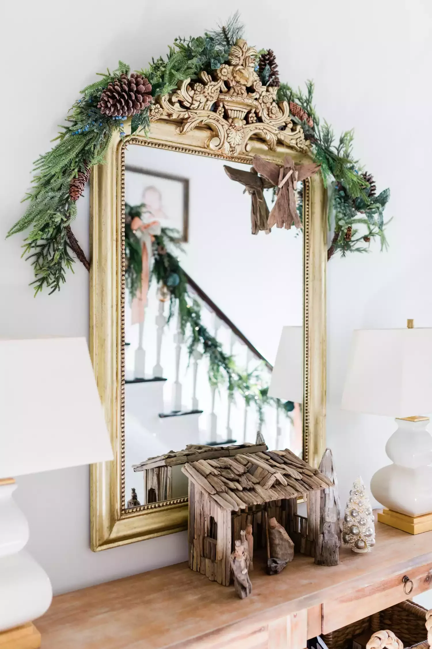 32 Stunning Christmas Wall Decorating Ideas to Transform Your Home Into a Holiday Haven 21 Greenery-Adorned Wall Mirror