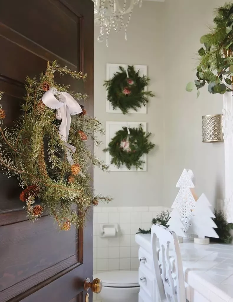 32 Christmas Bathroom Ideas That Create a Holiday Wonderland Layer Wreaths Over Art