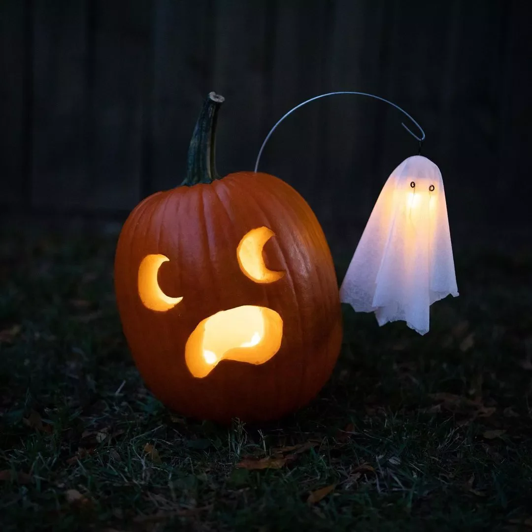 77 Creative Pumpkin Carving Ideas That'll Transform Your Fall Decorating Game 63 Pumpkin with Ghost Attached