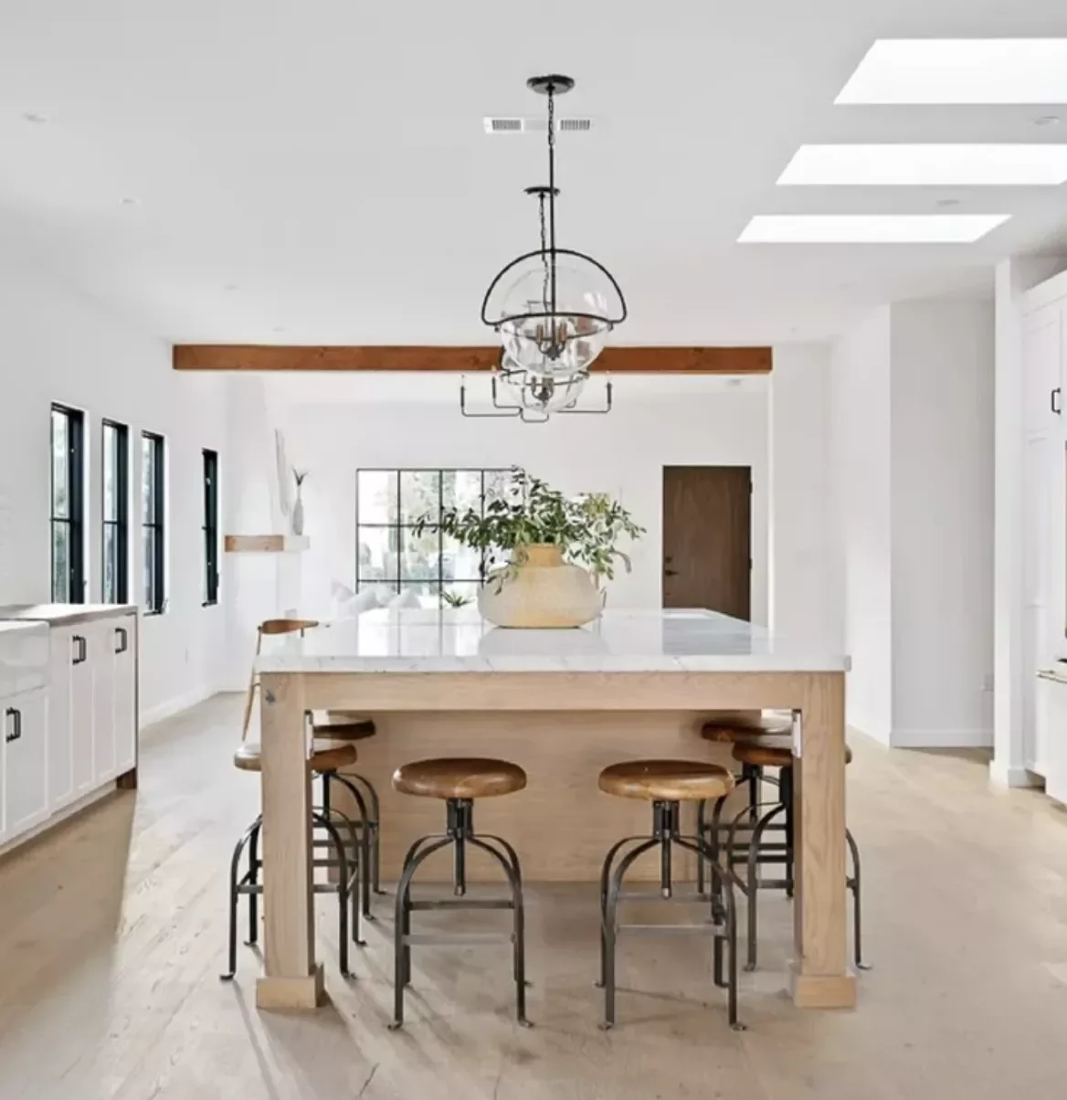 Wood-and-Stone Island With White Shaker Cabinets